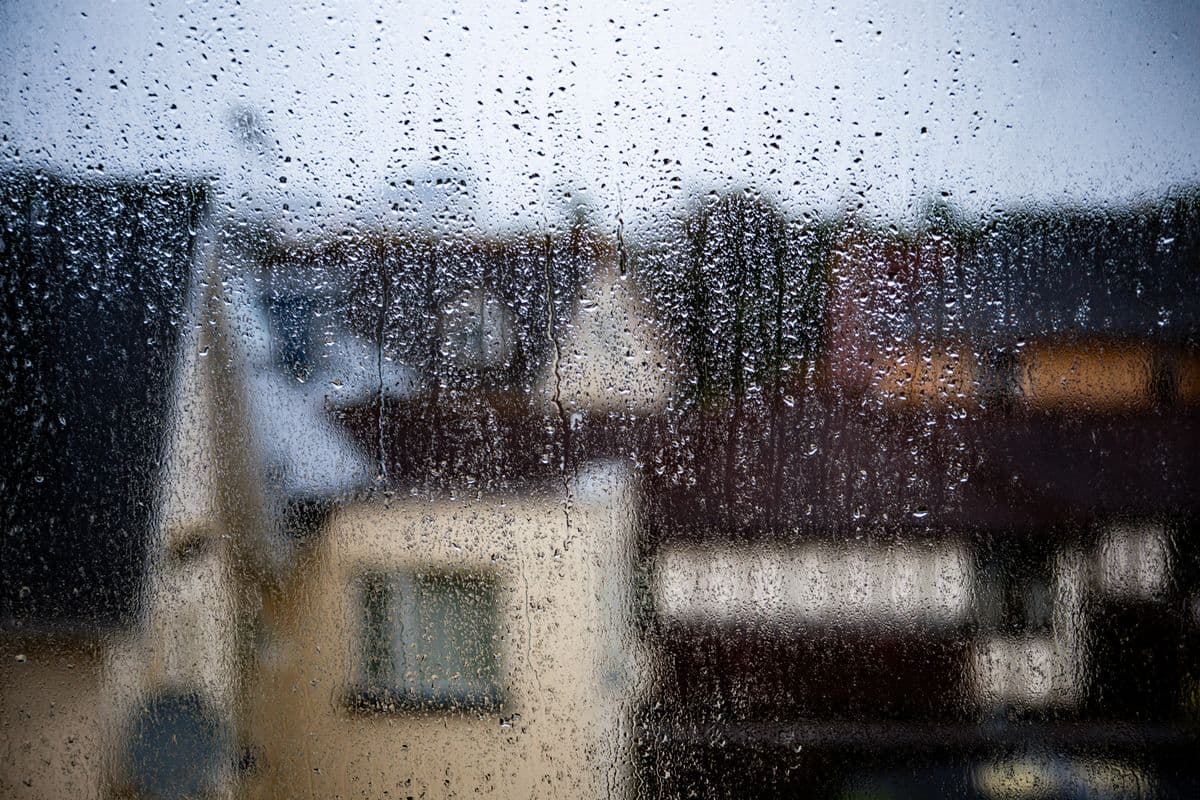 Rain streaking down a window over Kent rooftops