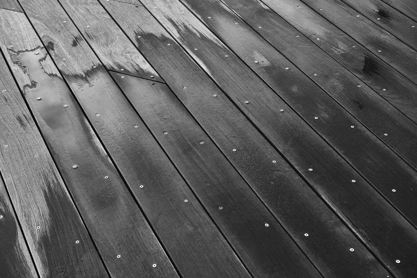 Water pooled on a dark wood floor after a leak